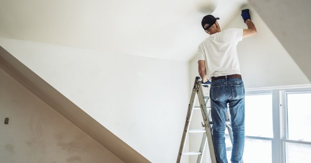 man in white interior painting