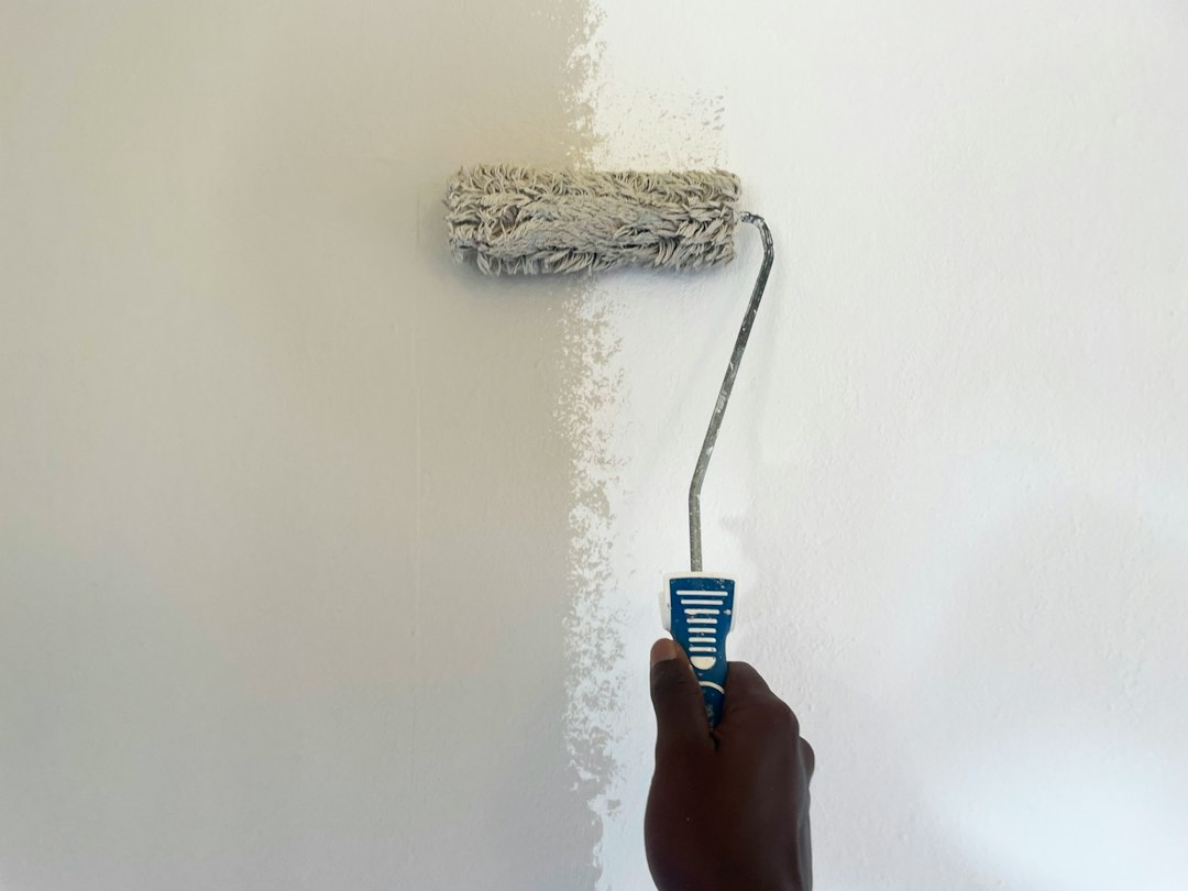 Painter priming and patching a wall before applying finish coat