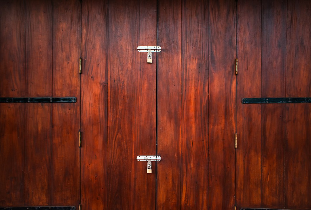 Painter applying wood stain to a cabinet door removed from its hinges